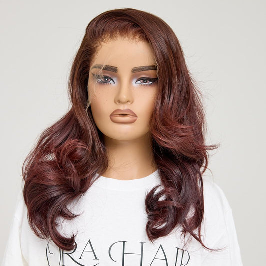 Mannequin head with a burgundy wig on a white background